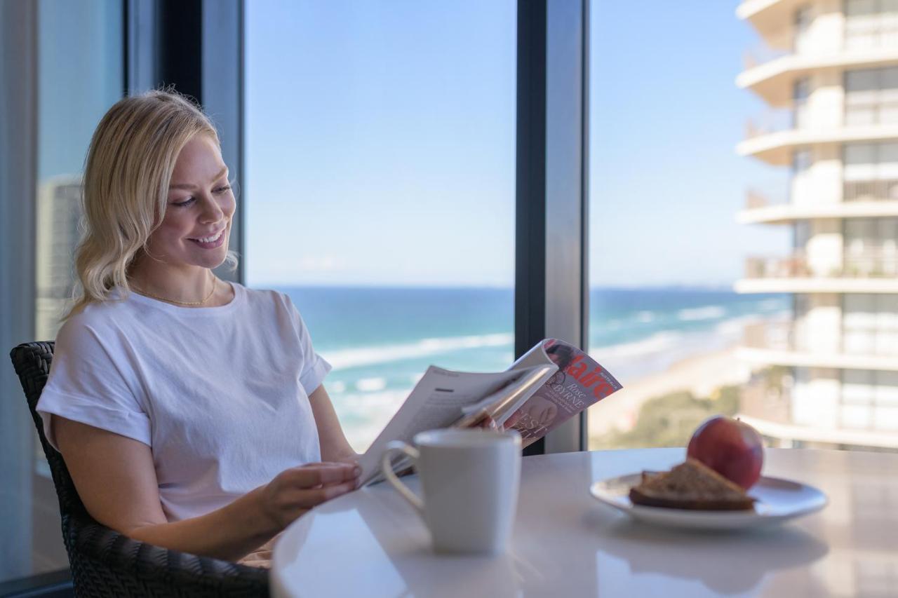 Meriton Suites Surfers Paradise Gold Coast Dış mekan fotoğraf A guest enjoys breakfast at the beachside balcony