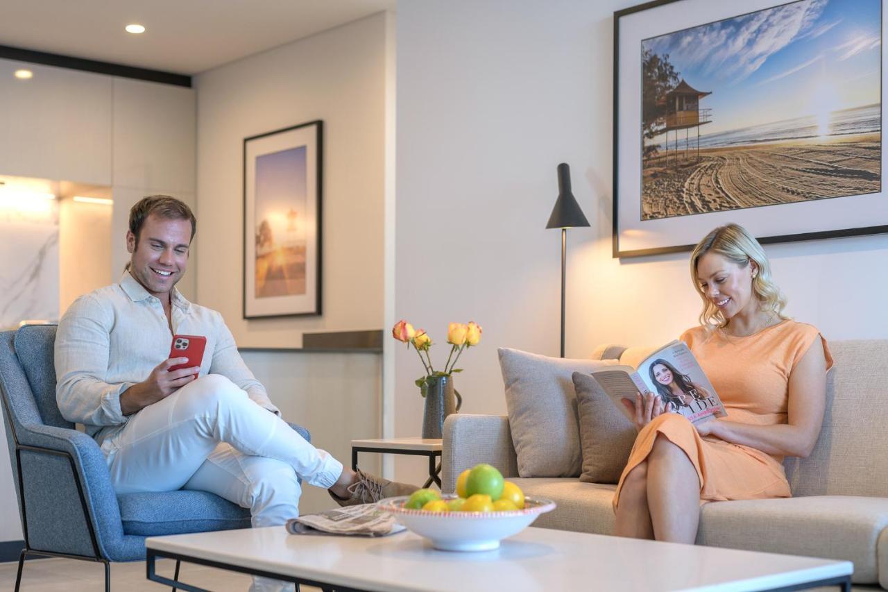 Meriton Suites Surfers Paradise Gold Coast Dış mekan fotoğraf A couple reading a magazine in their living room